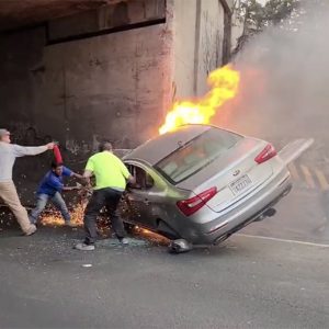 VIDEÓ: Elképesztő összefogással mentették a sofőrt és utasát a kigyulladt autóból a civilek