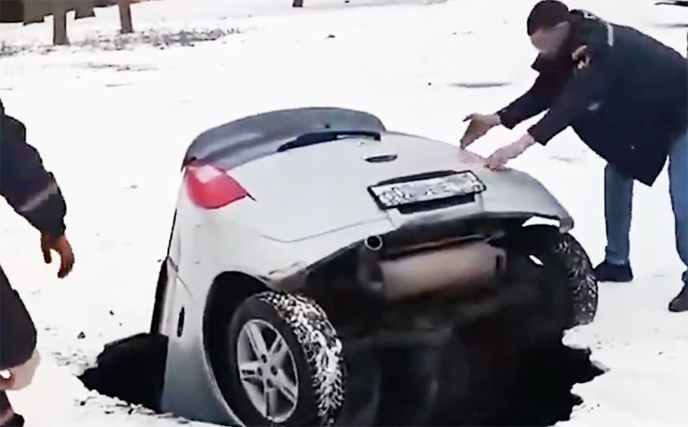 VIDEÓ: Csomagtartón keresztül kellett kimenteni az orosz nőt. Beszakadt az aszfalt az autója alatt