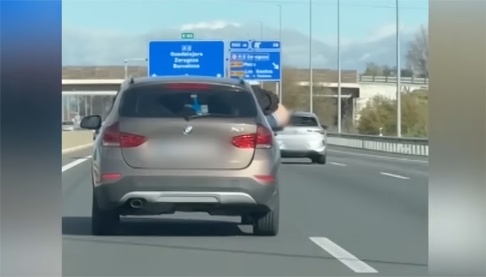 VIDEÓ: A hátsóját szellőztette az autópályán a BMW utasa egy spanyolországi autópályán. Keresi a rendőrség